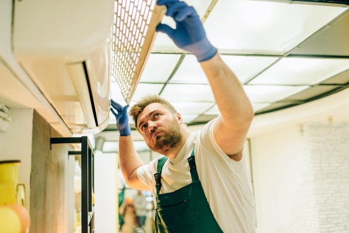 repairman-in-uniform-repairs-the-air-conditioner-NSH2EBC (1) (1)